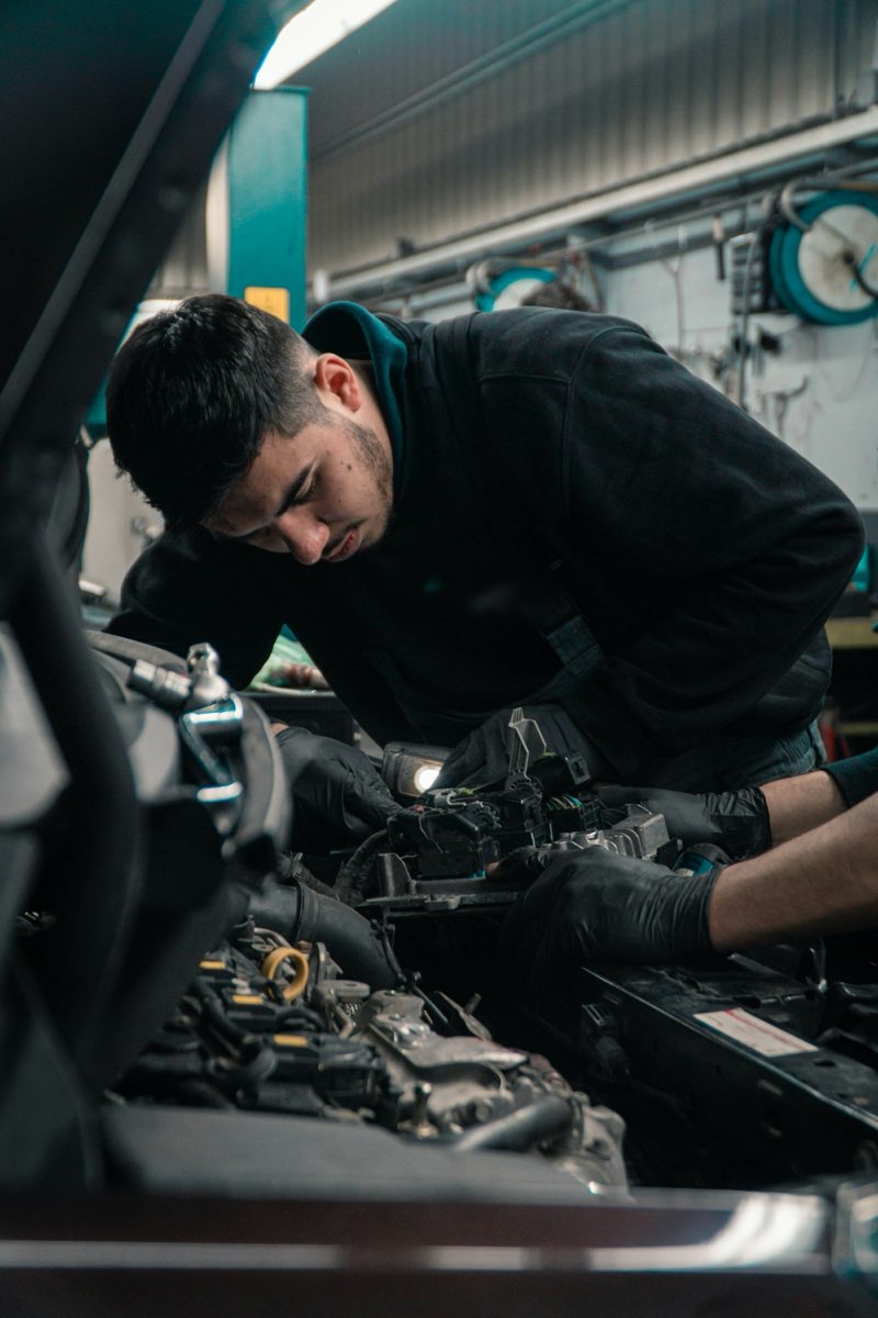 Automonteur werkt aan een motor in de garage