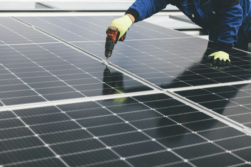 Installateur schroeft zonnepanelen vast